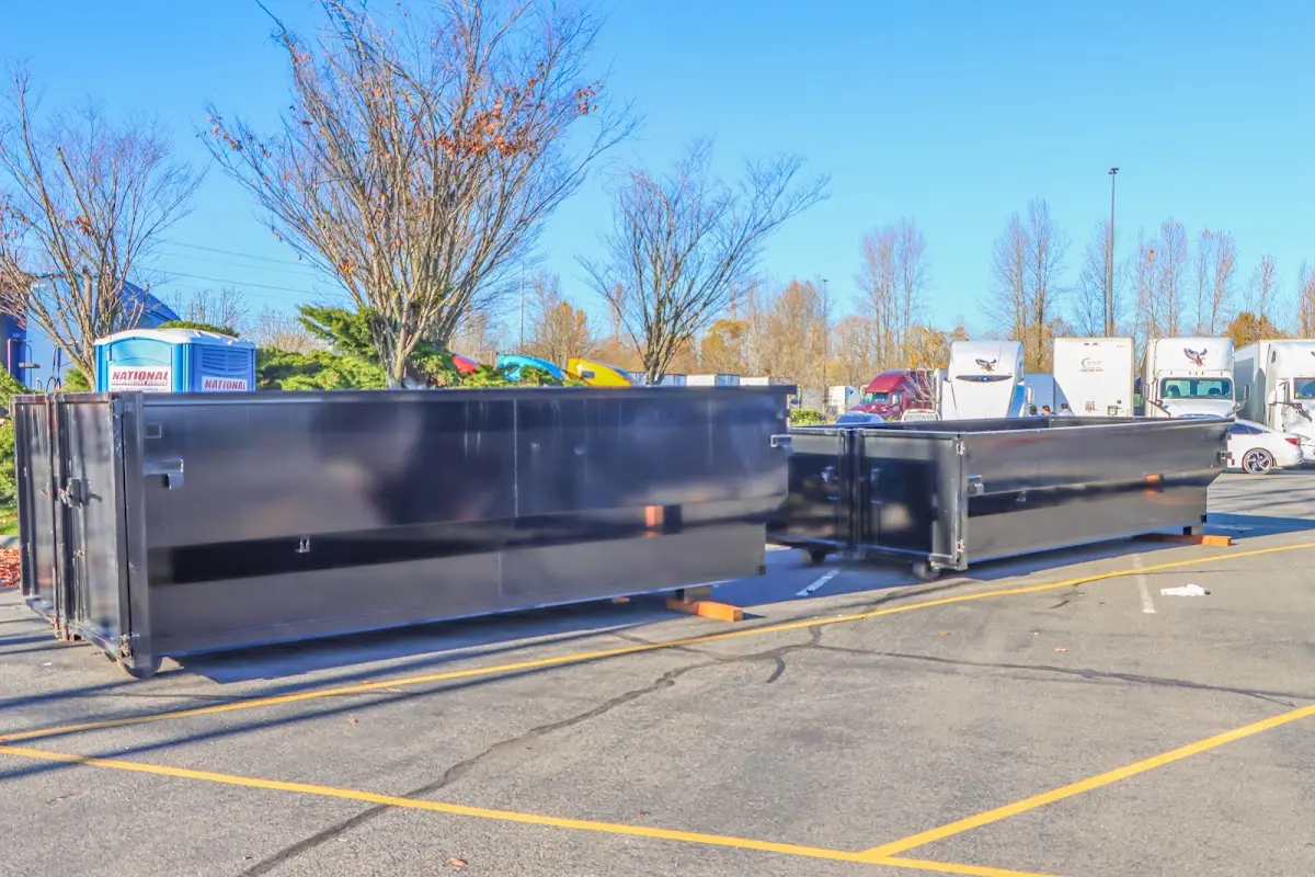 Professional dumpster rental service with roll-off container on residential driveway in Manasquan